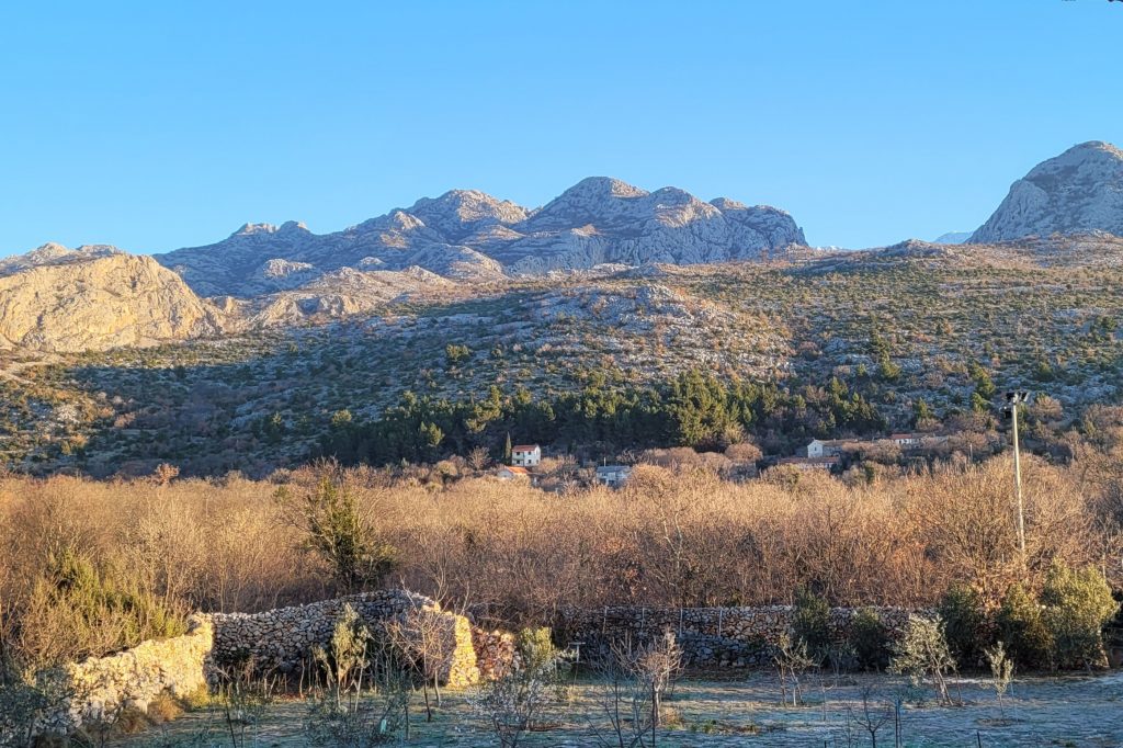 Azedara Apartments. Blick vom Hof auf die Hänge der Velika Paklenica mit Velebit im Hintergrund.