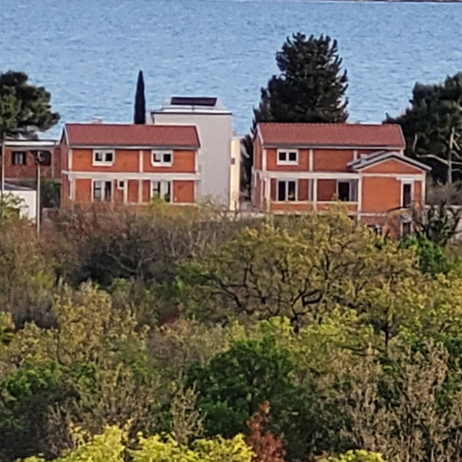 Azedara Apartments. Blick vom Wanderweg am Hang des Velebit auf die Häuser im Rohbau. Links das Gästehaus